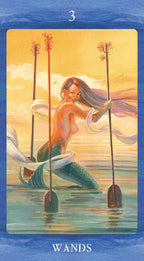 Tarot card featuring a mermaid holding wands with a sunset background