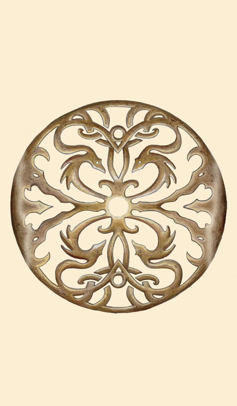 Decorative metal trivet with intricate patterns on a beige background