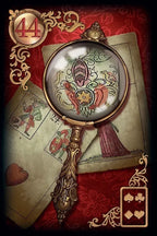 Decorative magnifying glass with intricate design on a red background with playing cards.