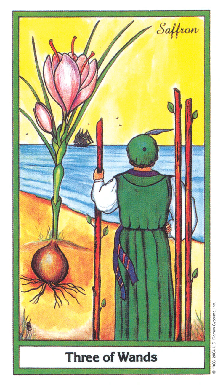 Tarot card titled 'Three of Wands' featuring a person in a green dress holding wands and a pink flower.