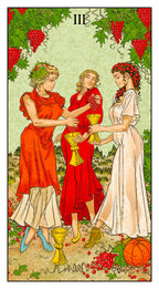 Tarot card with three women in red and white dresses, surrounded by fruits and vegetables.