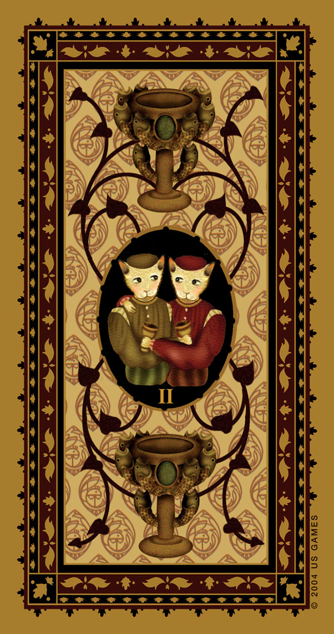 Decorative card with two cats holding a heart, surrounded by intricate designs on a beige background.