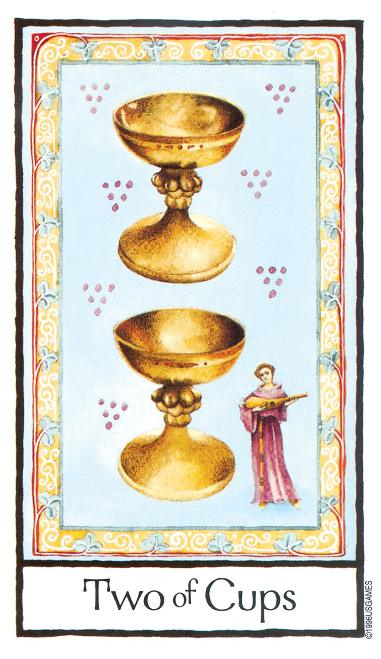 Two of Cups tarot card with two gold cups and a person holding a sword on a decorative border.