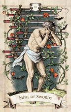 Tarot card featuring a man with his head in his hands, surrounded by swords and foliage.