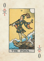 Card from a tarot deck featuring 'The Fool' with a person standing on a rock, surrounded by nature elements.