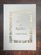Book titled 'The Book of Runes' by Ralph H. Blum on a wooden surface
