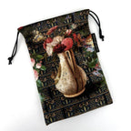 Decorative pouch with floral design and a vase of flowers on a white background