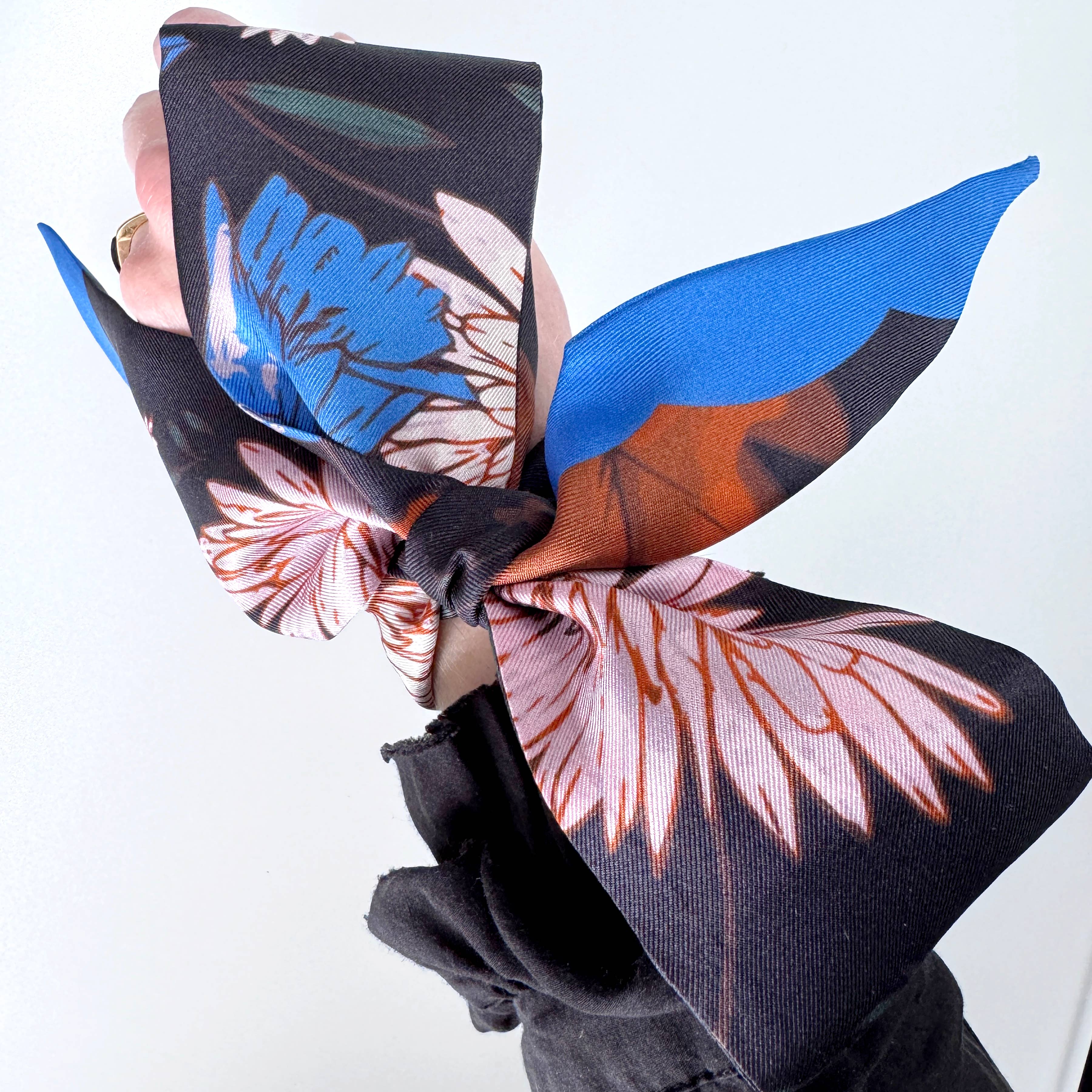 Floral patterned headscarf with blue and pink colors on a white background