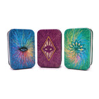 Three colorful tin boxes with abstract designs on a white background