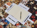 Notebook with pens on a decorative surface with tarot card designs
