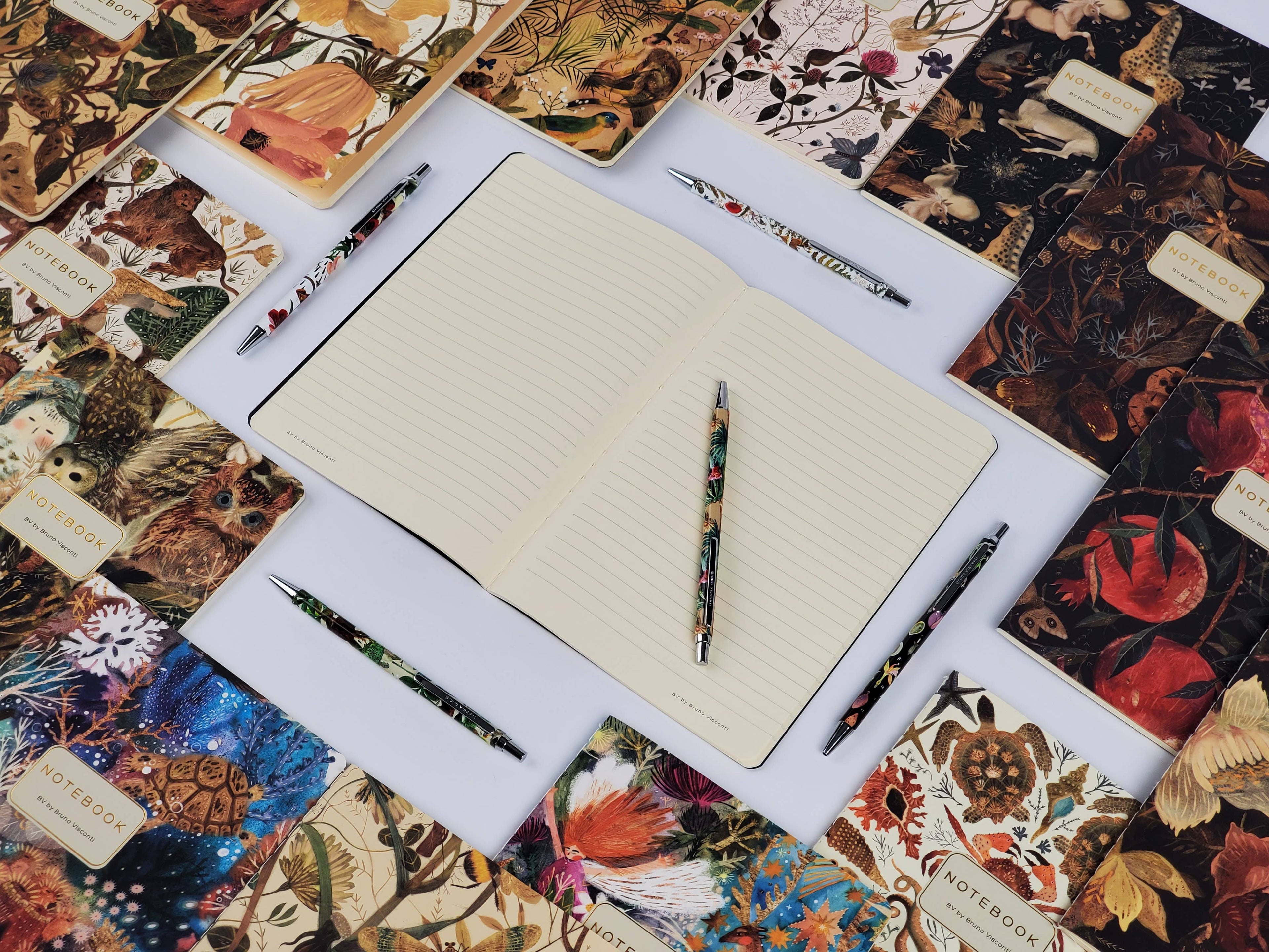Notebook with pens on a decorative surface with tarot card designs