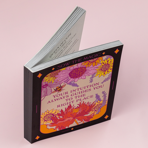 Decorative book with floral design and text on a pink background