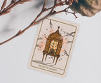 A tarot card titled 'Seven of Wands' featuring an illustration of a glowing lantern inside a wooden cage, styled on a light gray surface with decorative branches.