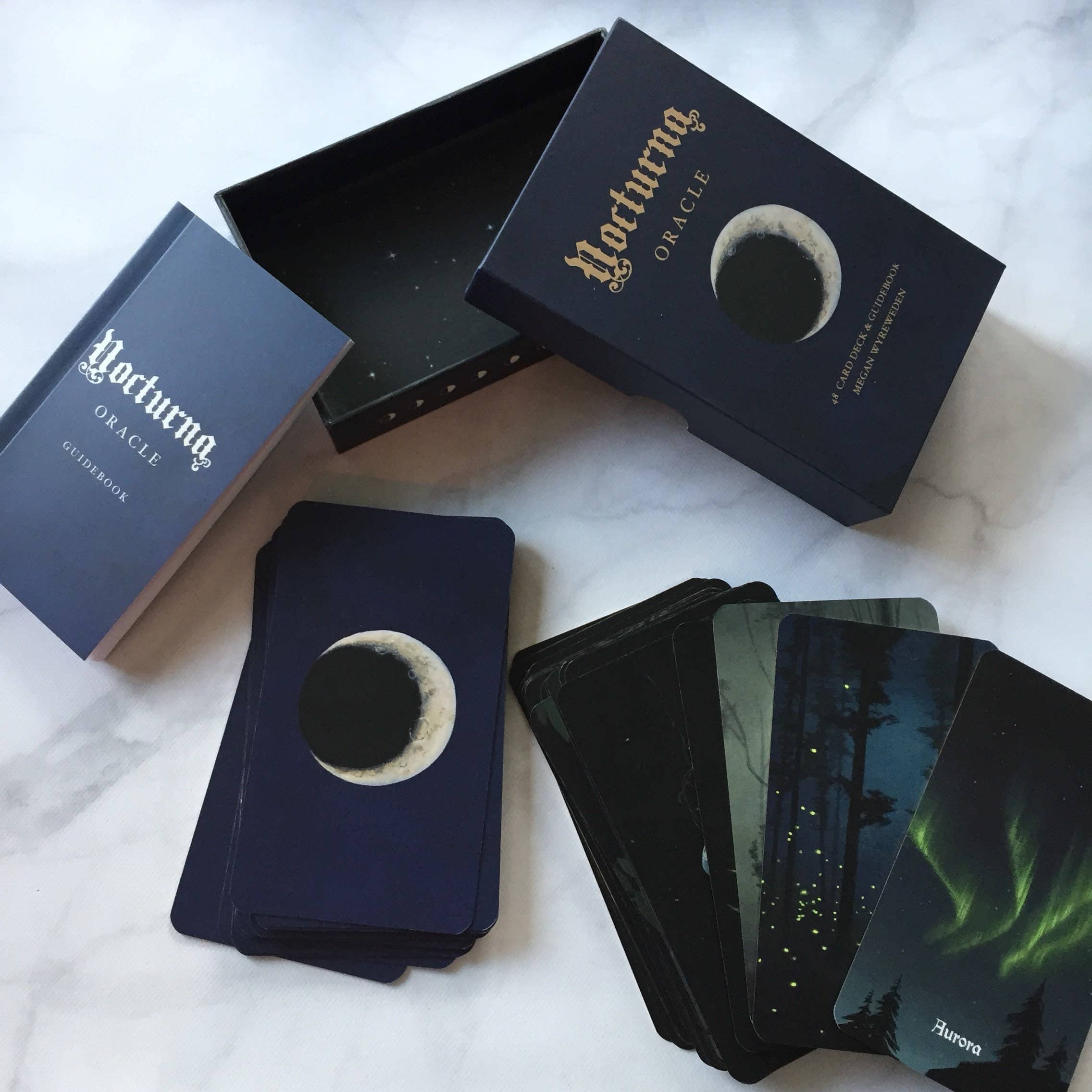 Nocturne Oracle cards with a moon design on a white fabric background