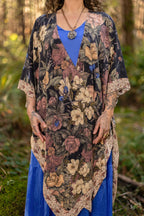 Person wearing a floral kimono over a blue dress in a forest setting