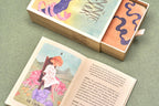 Open book with colorful illustrations on a green surface