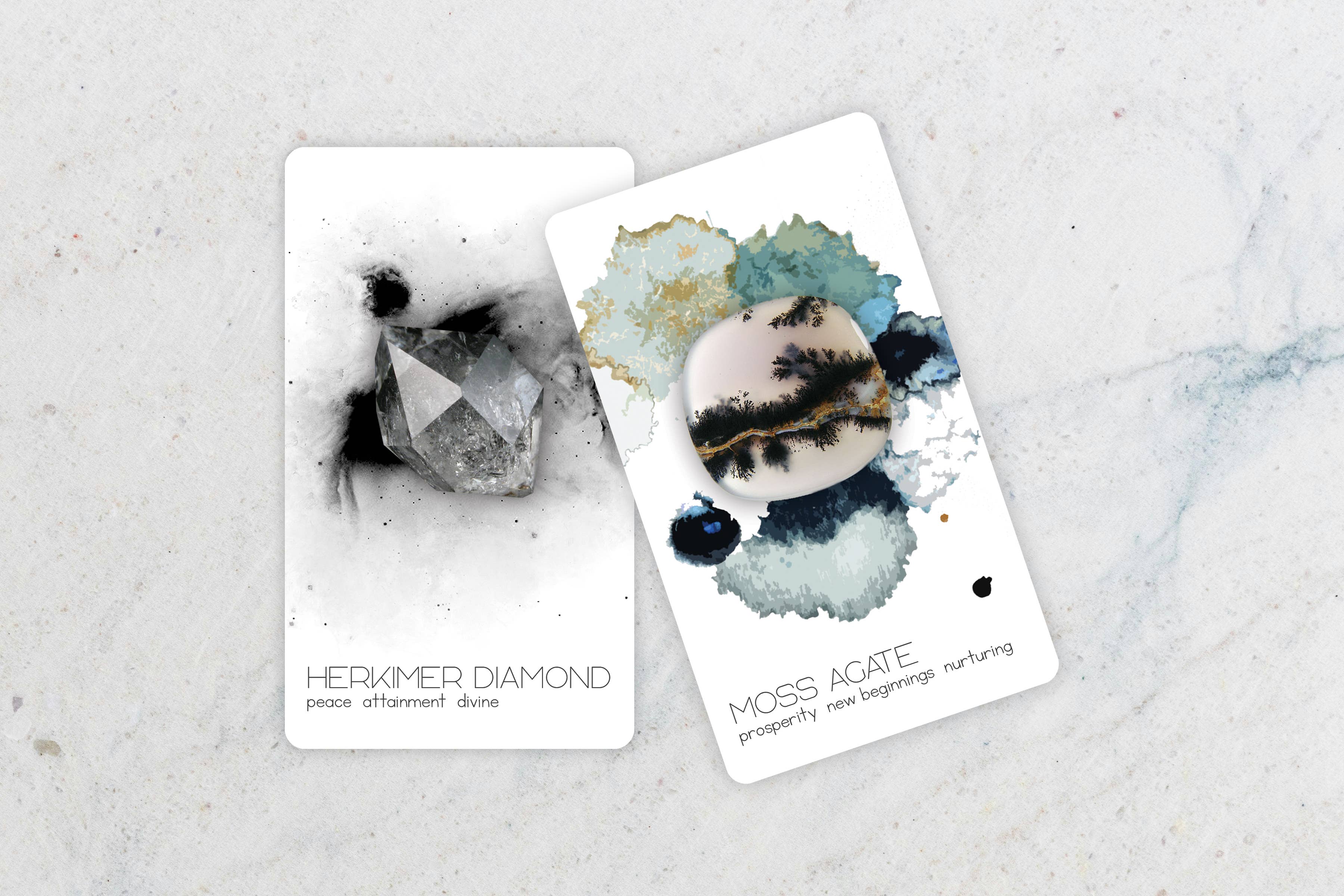 Two decorative cards laid on a light marble surface. One card shows a black-and-white crystal illustration with the text 'HERKIMER DIAMOND' and 'peace afterthought care.