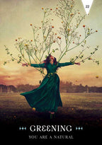 Person in a green dress with branches and leaves extending from their body, set against a scenic background.