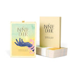 The Infinite Door: Book of 128 Tarot Cards by Pamela Love, shown with its illustrated box, a standing card deck, and a stack of cards on a white background.