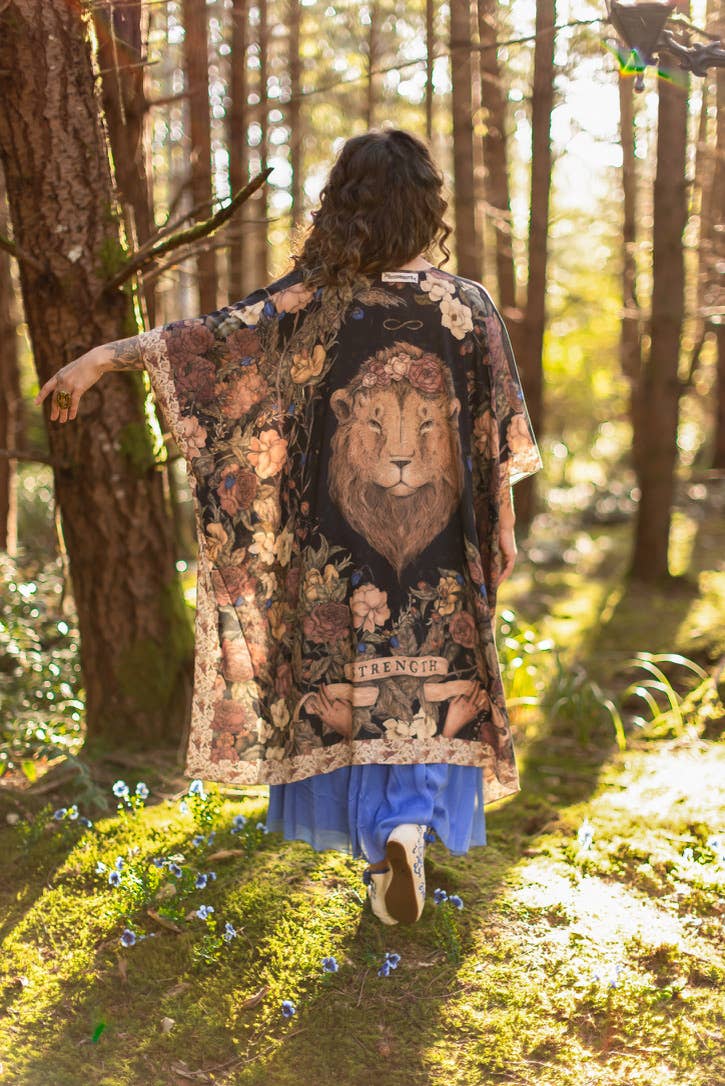 Person wearing a patterned kimono with a lion design in a forest setting