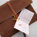 Brown fabric pouch with a label on a light gray background