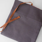 Gray fabric with brown leather straps on a light gray background