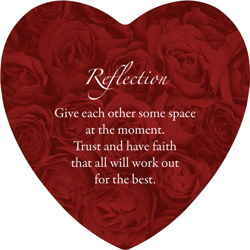 Heart-shaped arrangement of red roses with a reflective message on a white background