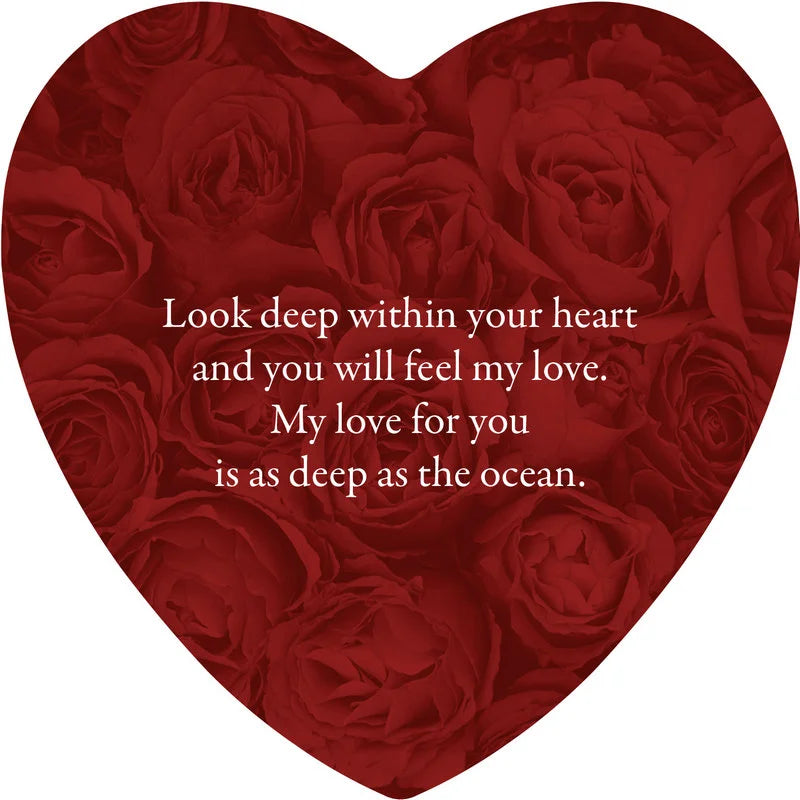 Heart-shaped arrangement of red roses with a romantic message on a white background