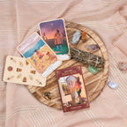 Tarot cards on a wooden board with crystals and a smudge stick on a soft pink fabric background