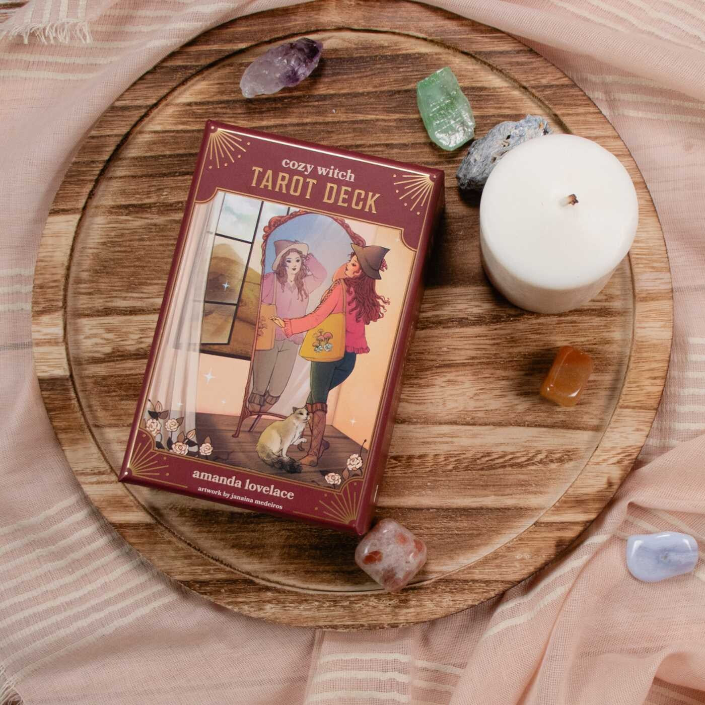 Cozy Witch Tarot Deck on a wooden surface with crystals and a candle
