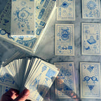 Collection of tarot cards with blue designs on a marble surface