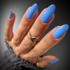 Hand with blue nail polish on a dark background