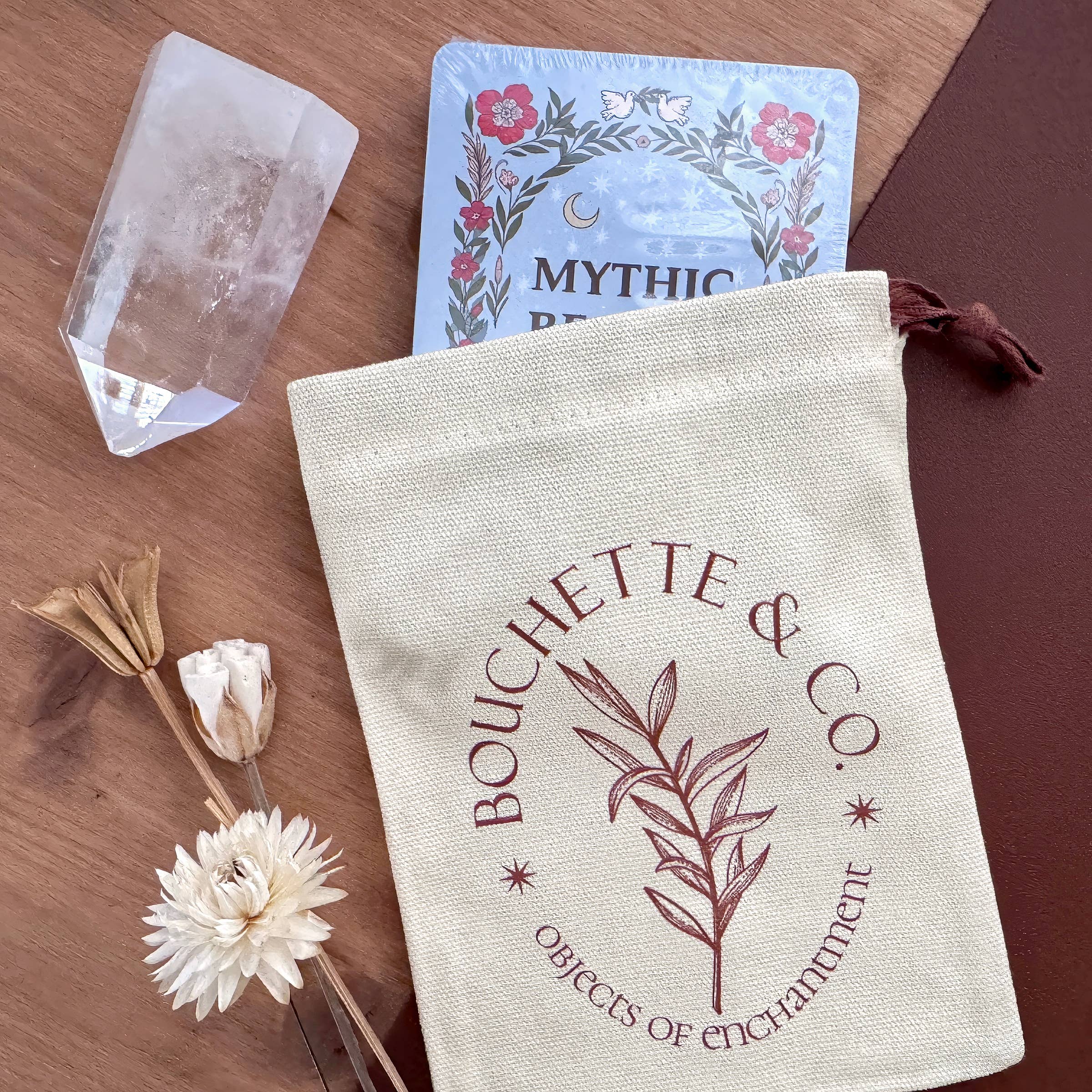 Bouchette & Co. pouch with cards and crystal on a wooden surface