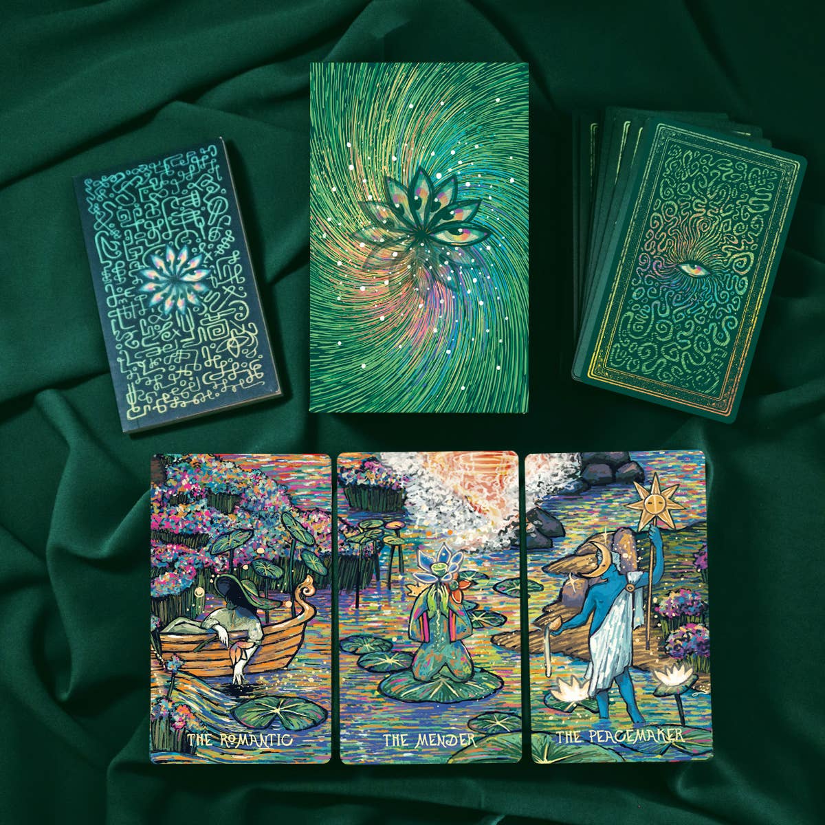 Collection of tarot cards with intricate designs on a dark green fabric background