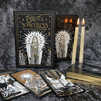 Tarot cards from 'Tarot of the Sorceress' with candles on a dark textured background