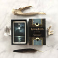 Anima Mundi Tarot set with a card featuring 'The Moon' and decorative elements on a marble surface.