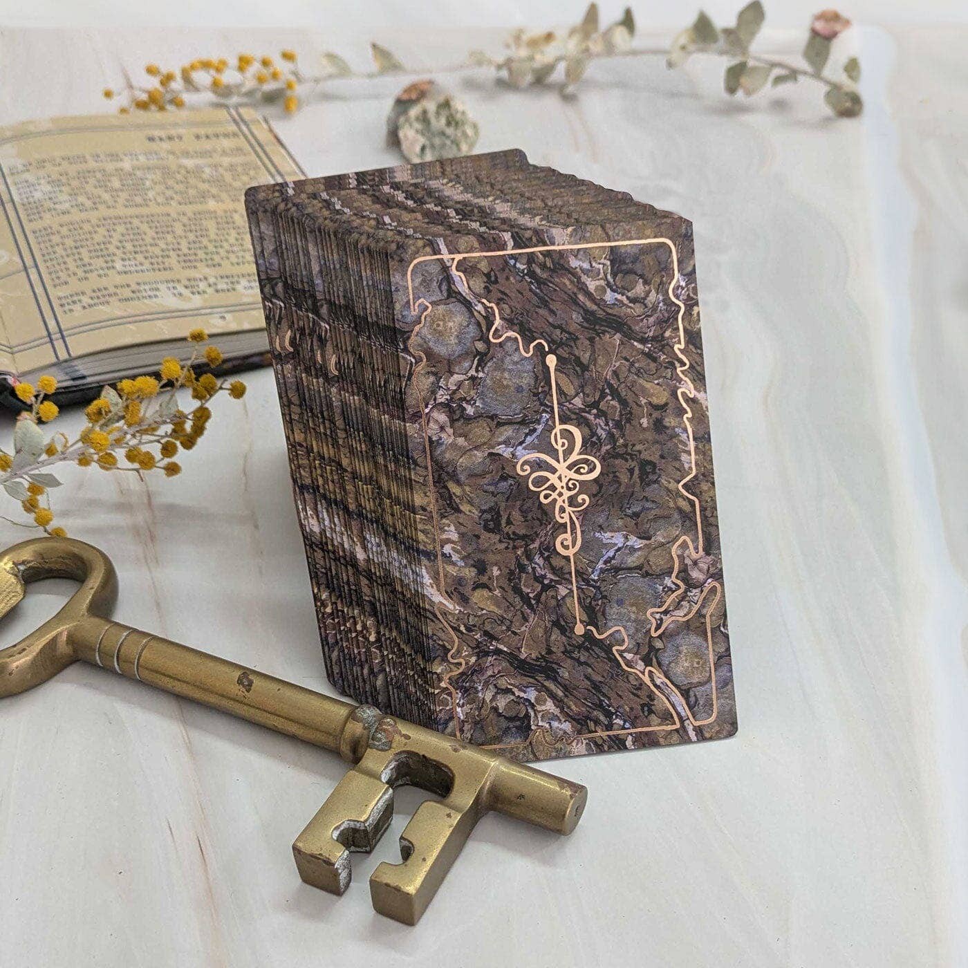 Decorative wooden box with intricate design, accompanied by a brass key on a light background.