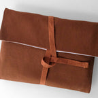 Brown fabric pouch with a knot on a white background