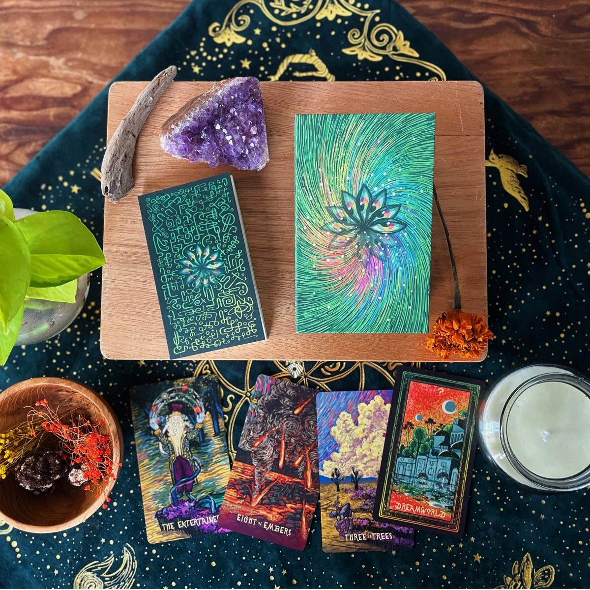 Set of tarot cards on a wooden board with crystals and candles on a dark fabric background.
