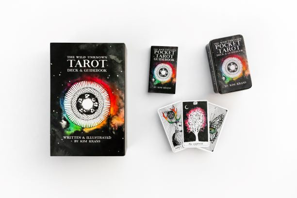 Collection of tarot cards and books on a white background