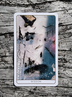 Card with abstract design and 'Wisdom' text on a textured surface