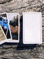 Three tarot cards on a wooden surface with scenic images.