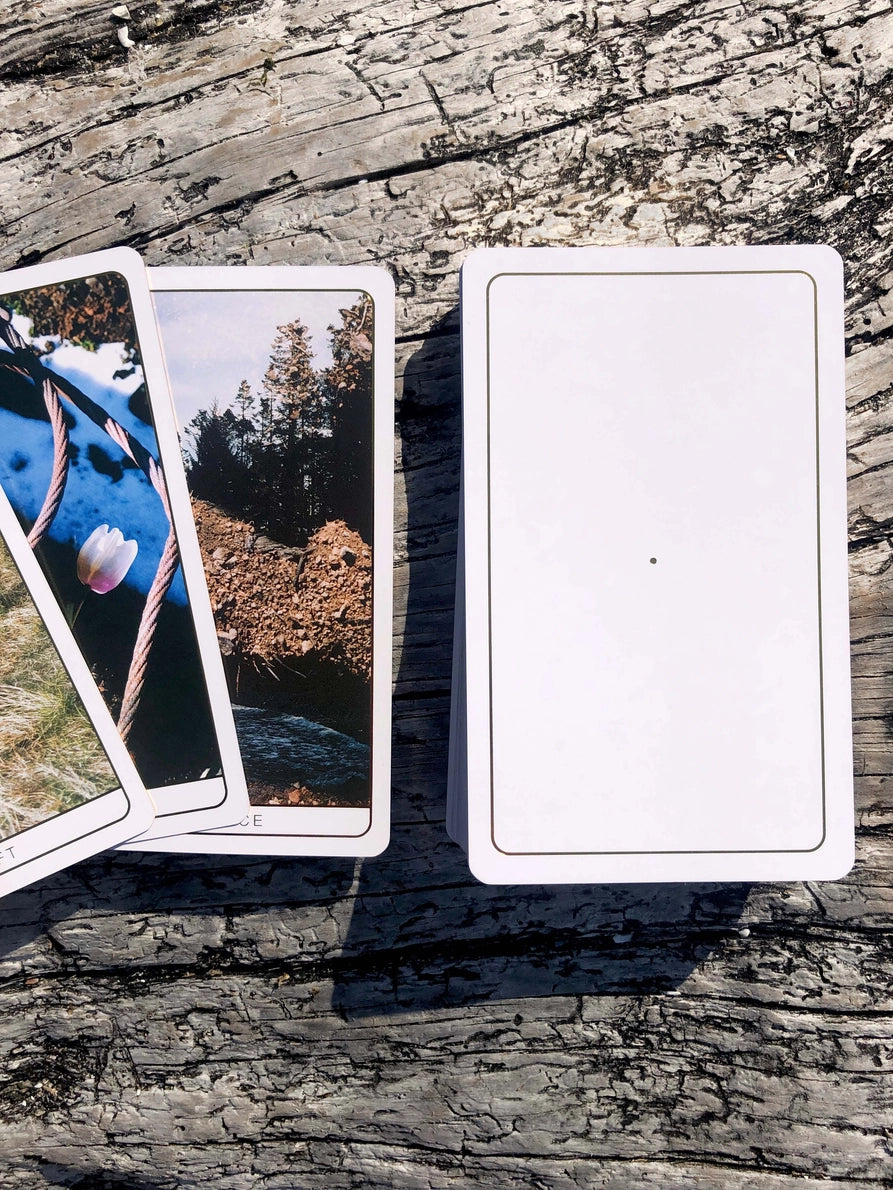 Three tarot cards on a wooden surface with scenic images.