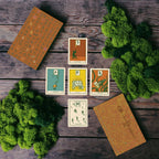 Set of tarot cards on a wooden surface with green foliage