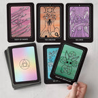 Collection of tarot cards with artistic designs on a light gray surface.
