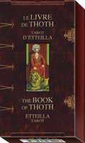 Tarot deck box with 'Le Livre de Thoth' and 'The Book of Thoth' text, featuring a tarot card illustration on a dark brown background.