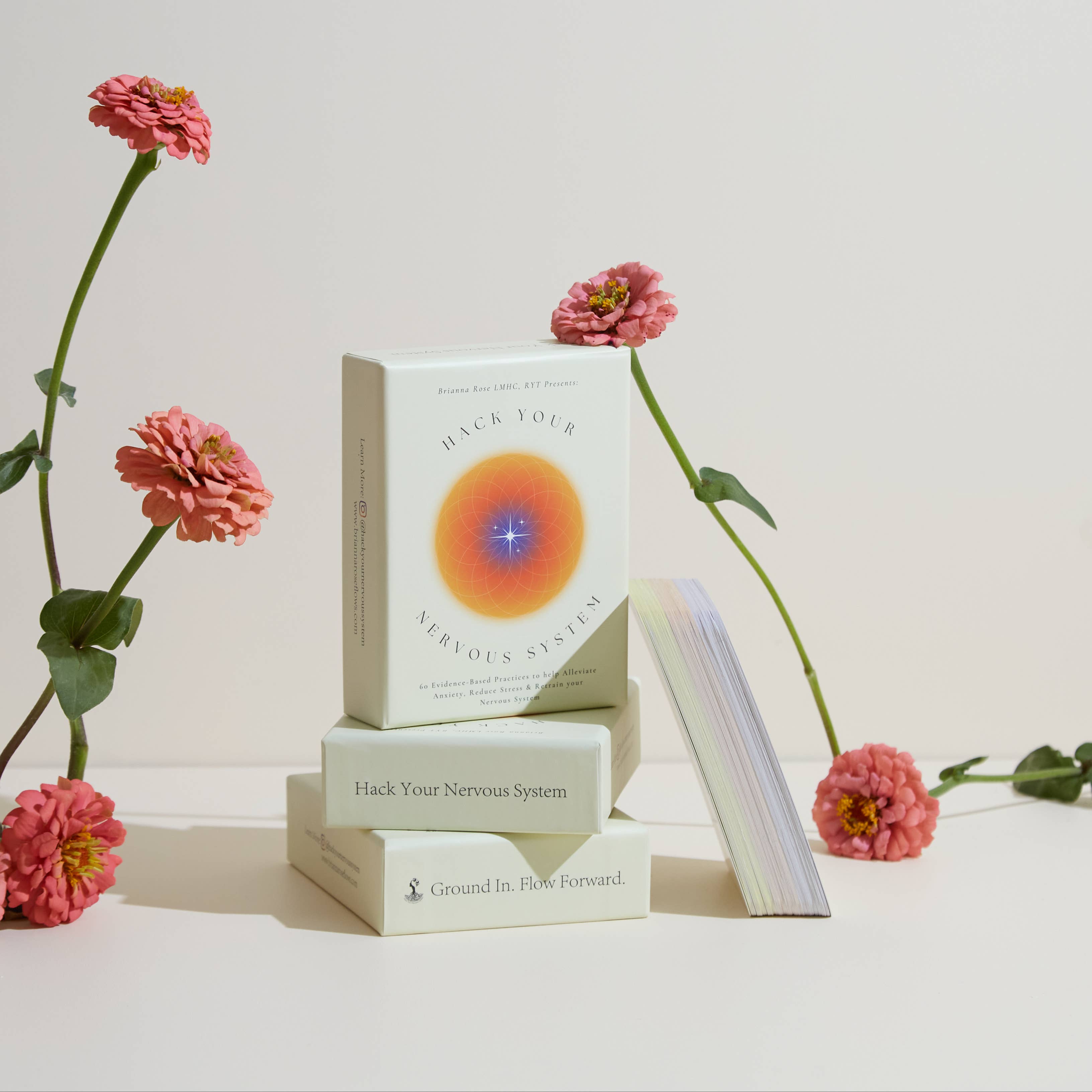 Book titled 'Hack Your Nervous System' with pink flowers on a light background