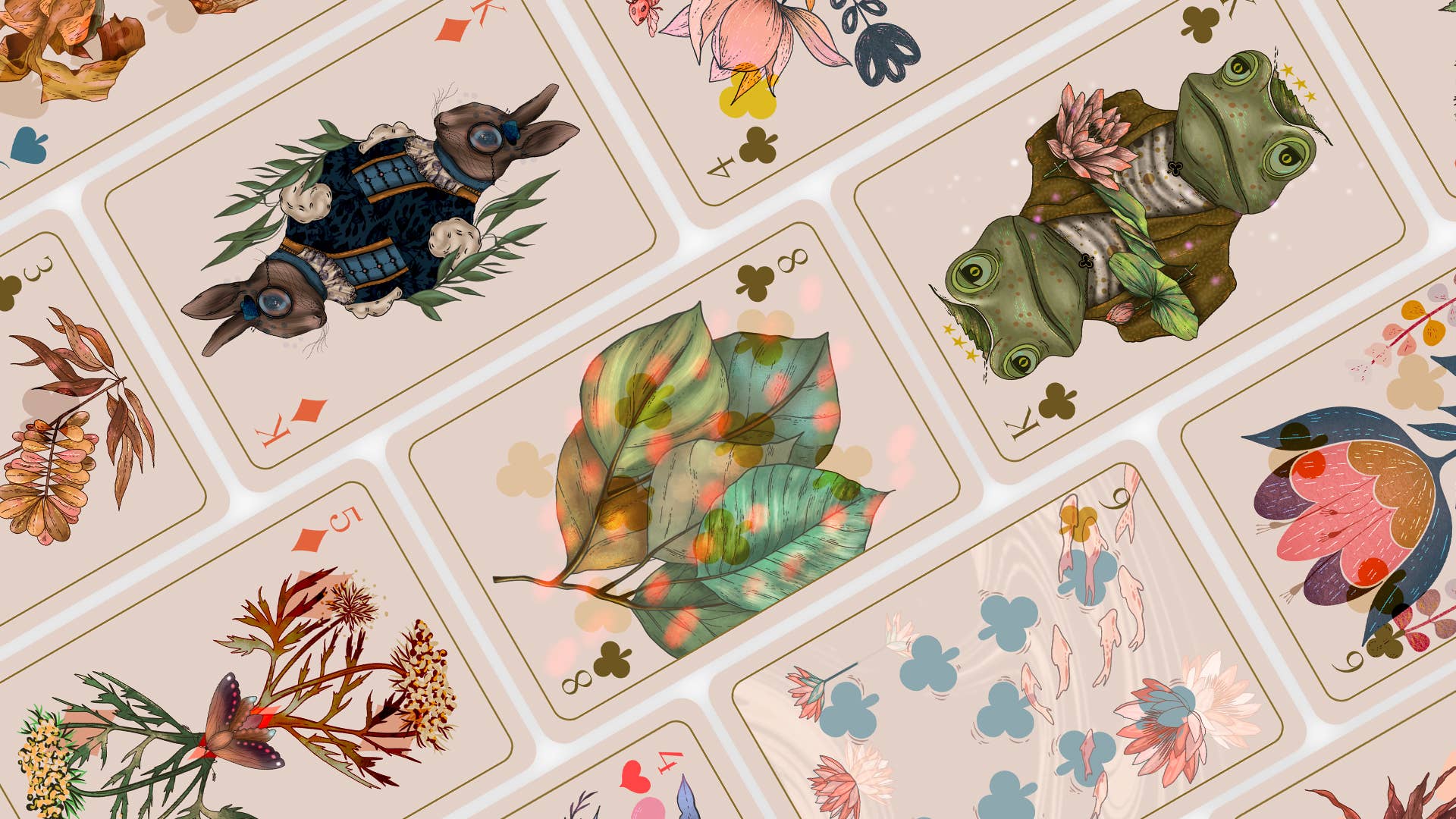 A close-up of illustrated playing cards arranged diagonally, showing whimsical nature-themed artwork including a rabbit, green frog, leaves, flowers, and birds on a pale pink card background.