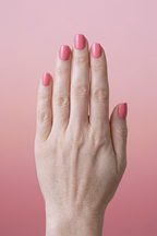Hand with pink nail polish on a pink background