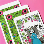 Colorful playing cards with decorative designs on a pink background